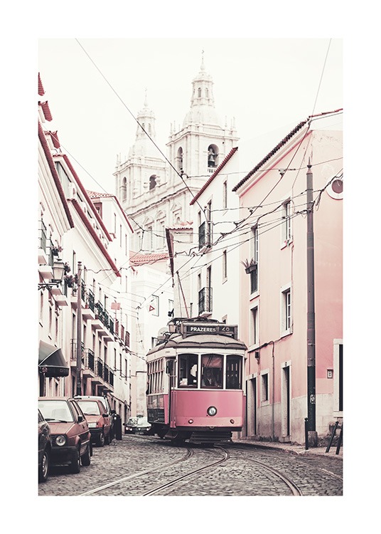  – Zdjęcie różowych i białych budynków po obu stronach drogi z tramwajem pośrodku