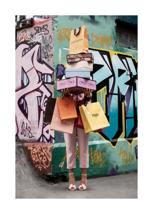  – Zdjęcie kobiety trzymającej pudełka na buty i torby na zakupy na tle ściany z graffiti