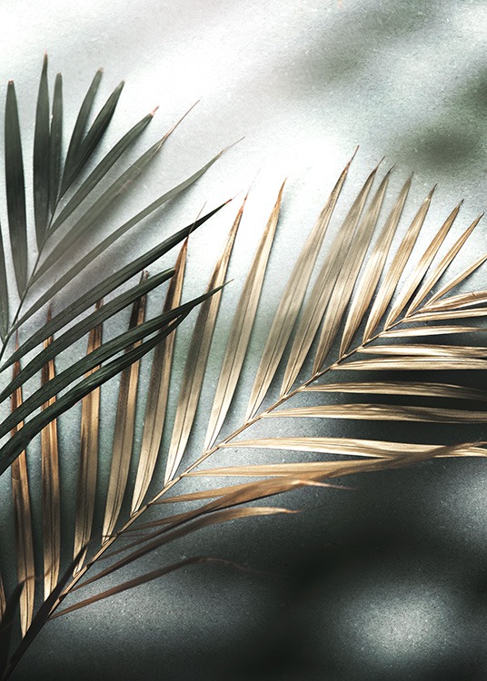  – Zdjęcie pary liści palmowych w kolorach złotym i zielonym na kamiennym tle