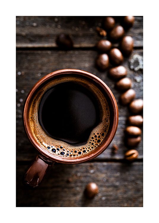  – Zdjęcie z góry z filiżanką kawy na drewnianym stole, z ziarnami kawy z boku
